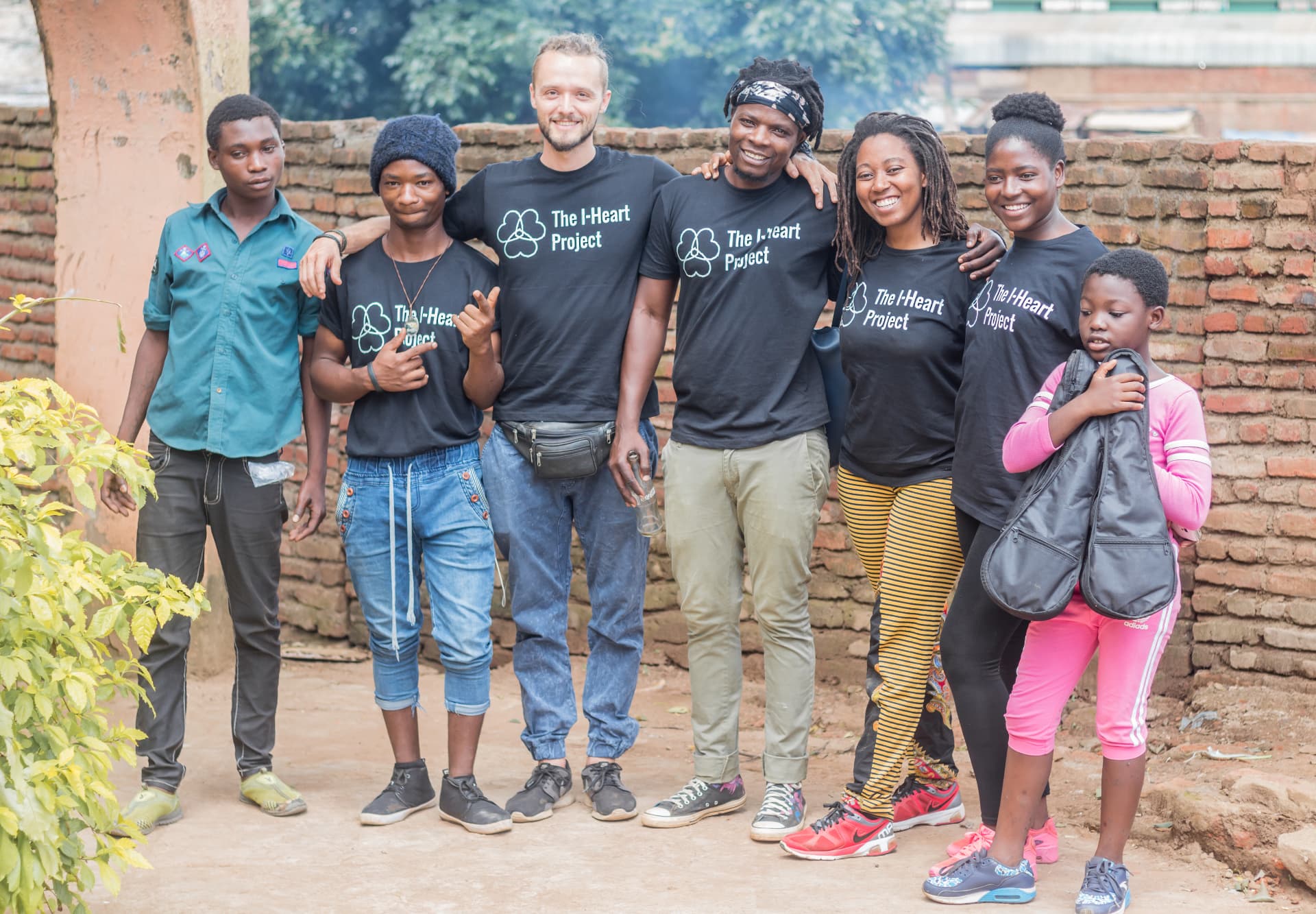 The I·HEART team in project T-shirts standing together in front of a brick wall