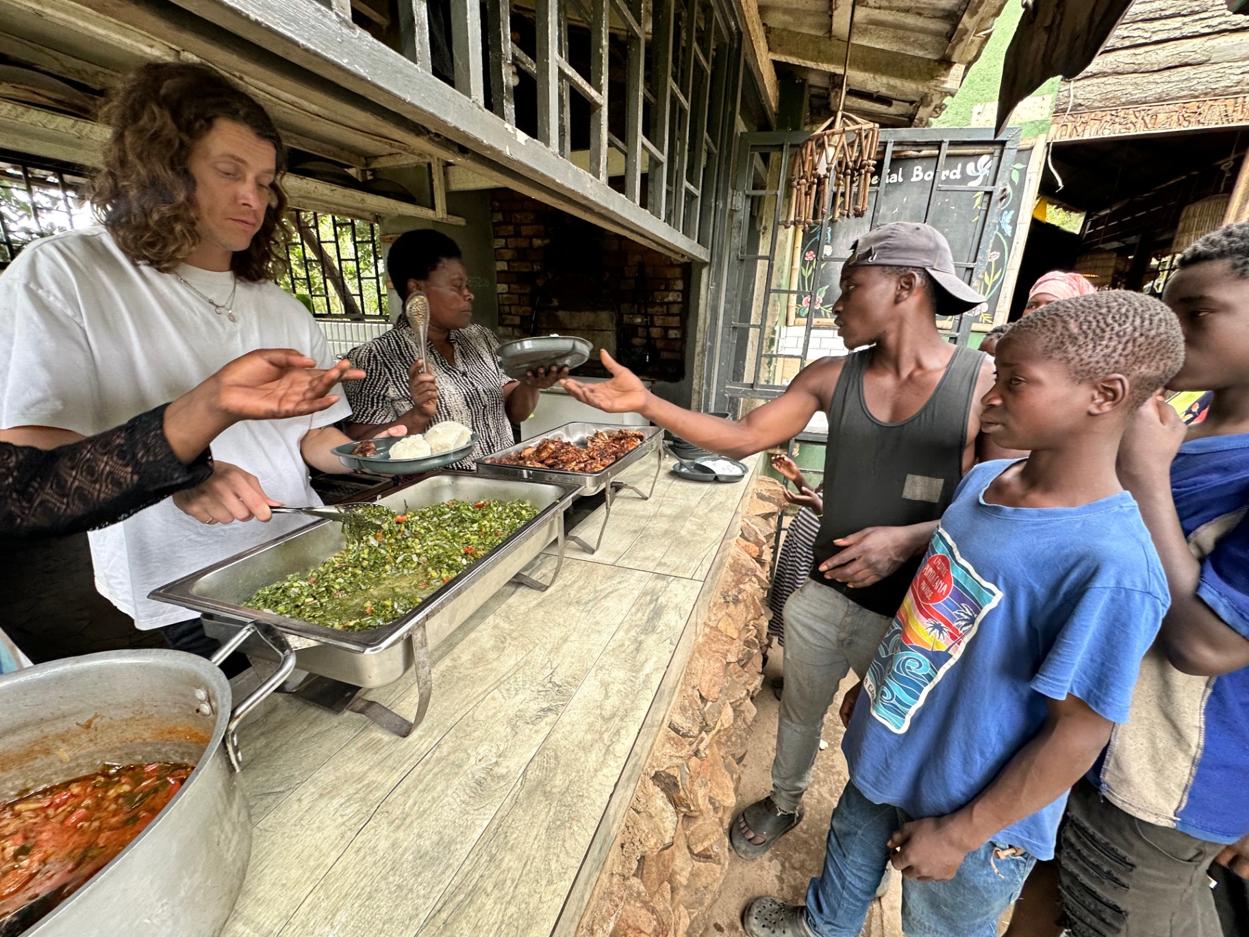 Volunteers and a Malawian colleague serving a shared meal to young people in the city